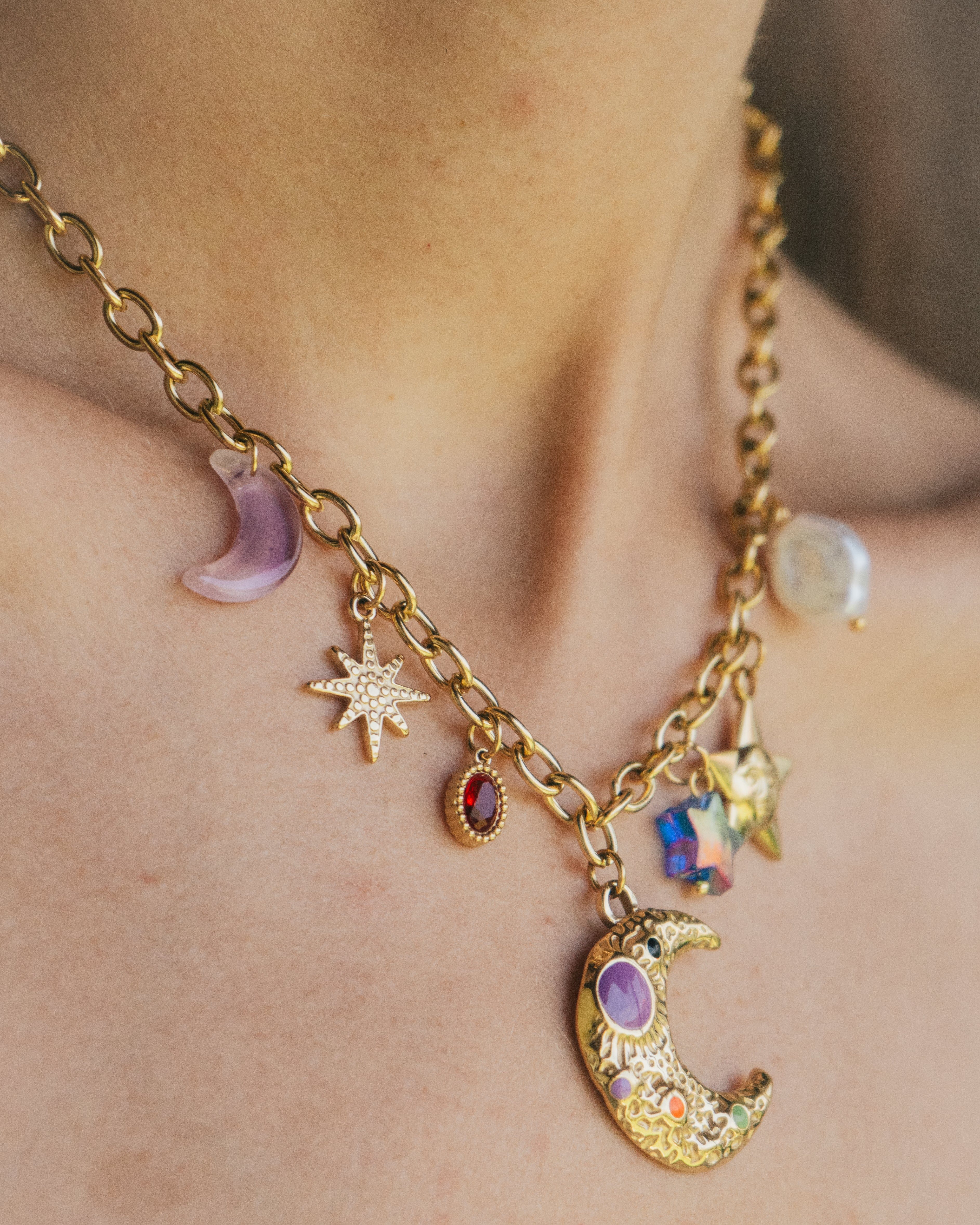 Necklace with moon and star charms on a person's neck