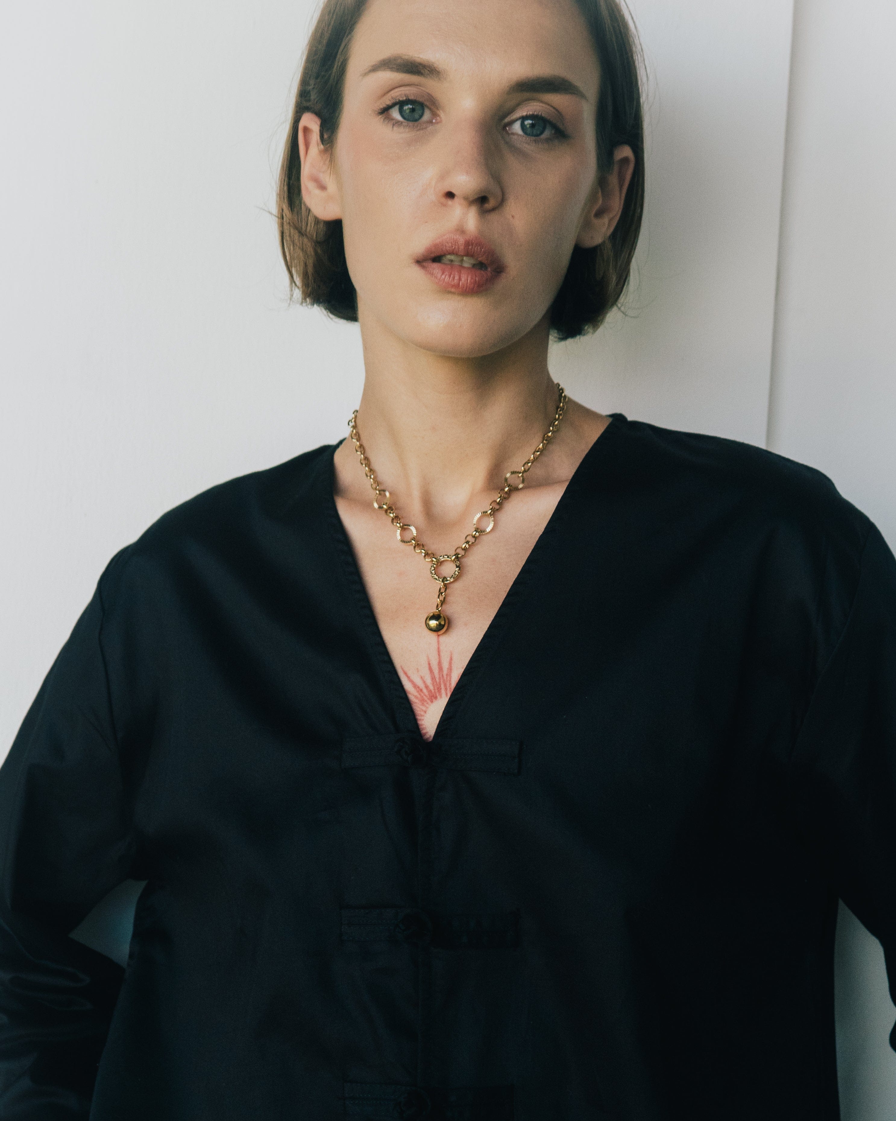Woman wearing a black blouse with a plain background